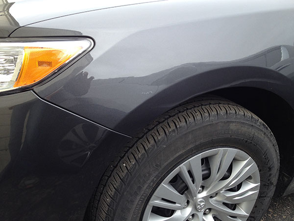 Front fender dent fully repaired using paintless dent repair on gray vehicle in Fife Lake, Michigan