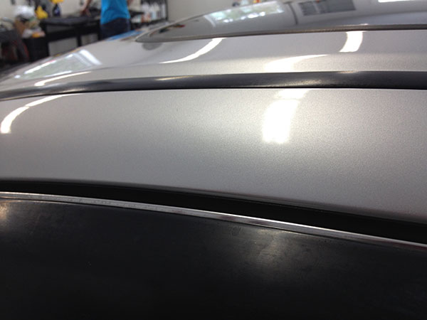 After paintless dent repair on a vehicle roof rail in Fife Lake, Michigan by Collins Dent Werks, showing smooth panel and factory paint finish restored.