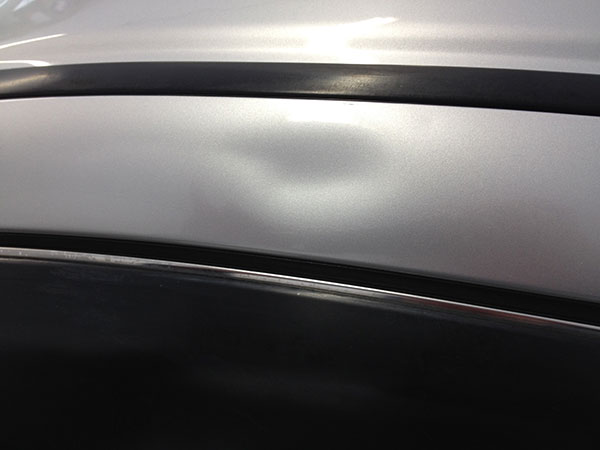 Roof rail dent before paintless dent repair in Fife Lake, MI by Collins Dent Werks