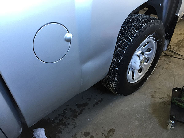 Chevrolet Silverado side panel with dent damage before paintless dent repair in Fife Lake, Michigan