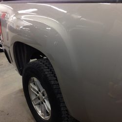 Rear bed side panel of a pickup truck after paintless dent repair, showing a smooth surface above the rear wheel.