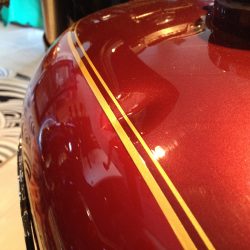 Harley-Davidson motorcycle fuel tank with visible dent before paintless dent repair at Collins Dent Werks in Fife Lake, Michigan