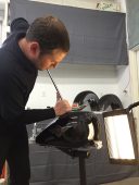 Technician performing paintless dent repair on a Harley-Davidson motorcycle fuel tank at Collins Dent Werks in Fife Lake, Michigan