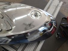 Motorcycle fuel tank dent repair in progress at Collins Dent Werks in Fife Lake, Michigan