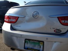 Rear view of a silver Buick Verano showing the trunk lid, Buick emblem, taillights, and rear bumper.