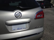 Rear view of a silver Buick Enclave showing the tailgate, rear emblem, license plate area, and right taillight.