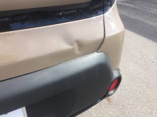 Kia rear panel showing dent damage before paintless dent repair at Collins Dent Werks in Fife Lake, Michigan