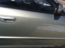 Subaru door panel after paintless dent repair, showing a smooth surface where a crease was removed.