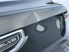 Dent visible on the front driver-side fender of a black GMC Sierra pickup truck near the 5.3L V8 emblem.